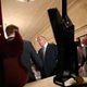 Trump shakes hands with business owners in front of a display of Marucci guitars.